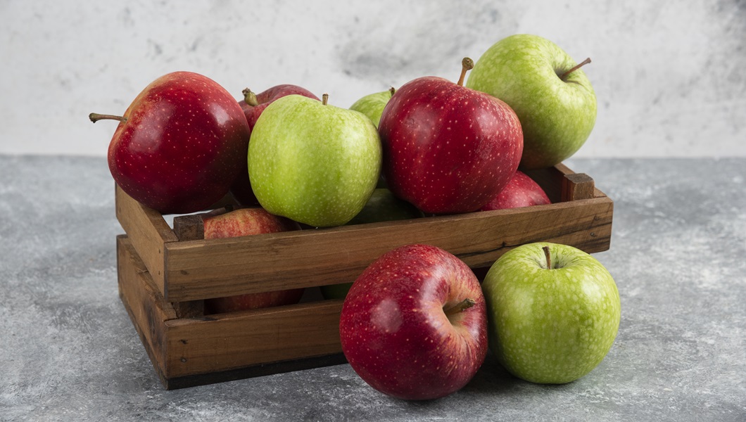 Fresh delicious green and red apples in wooden box