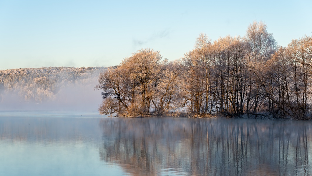 Beautiful misty morning at sunrise, dawn, at a lake.