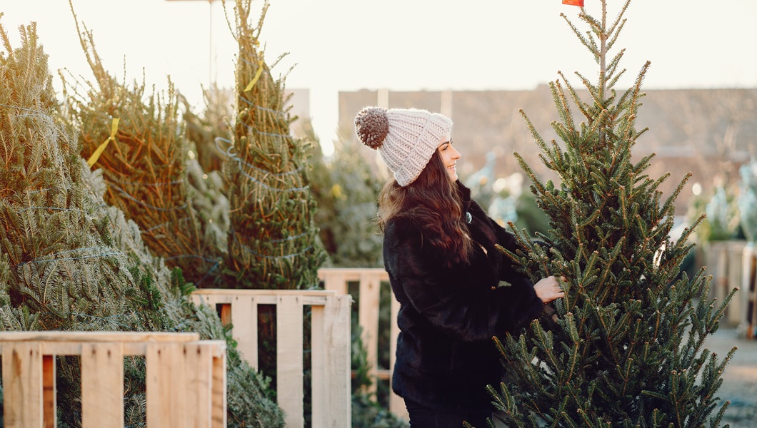 Cute brunette in a white sweater with Christmas tree