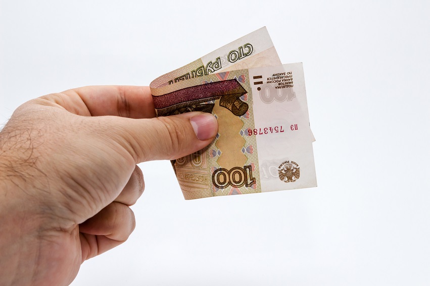 High angle closeup shot of a person holding a banknote over a white background