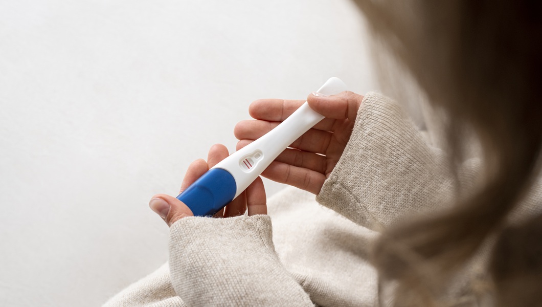side-view-woman-holding-positive-pregnancy-test