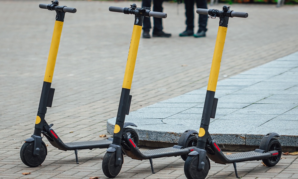 Selective focus shot of three electric scooters on the sidewalk